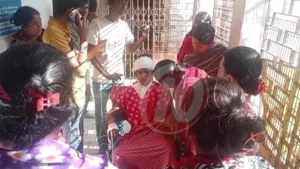 Injured person surrounded by people at hospital entrance.