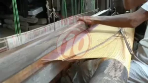 Person weaving fabric on traditional loom