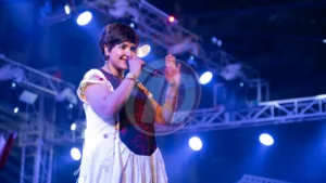 Singer performing on stage with bright lights