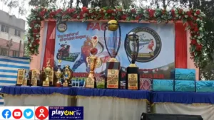 Cricket league trophies displayed on decorated stage.